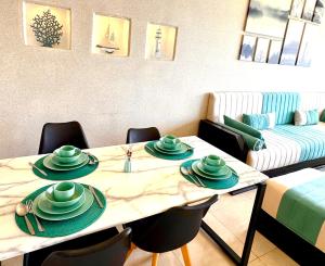 a living room with a table with green dishes on it at Ocean Therapy in Dar Oulad Hajj Kassem
