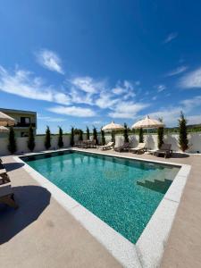 a pool with chairs and umbrellas on a building at Villa Azur in Draç