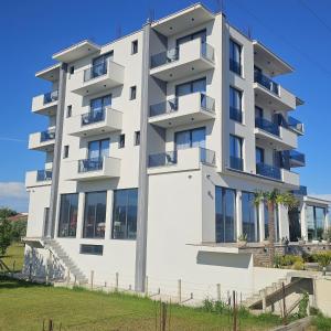 a tall white building with windows at AnDora in Donji Štoj