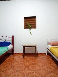 a room with two beds and a table and a window at Carioca Lapa Hostel in Rio de Janeiro