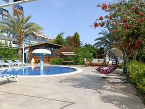 a patio with a pool and a chair and a table at Graf Victor Apart Hotel in Alanya