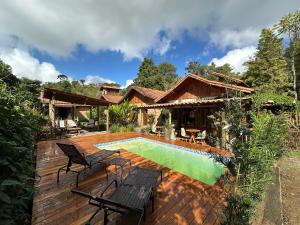 a backyard with a pool and a house at Pousada Trilha das Àguas in Visconde De Maua