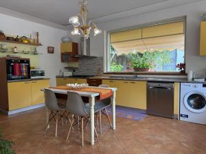 a kitchen with yellow cabinets and a table and chairs at Casa Alessandra in Arezzo