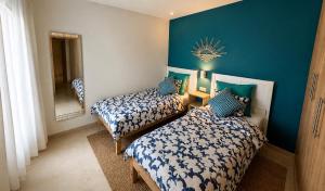 two beds in a room with blue walls at Ocean Therapy in Dar Oulad Hajj Kassem +13 photos