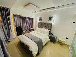 a bedroom with a large bed in a room at The Royal Enclave in Abuja