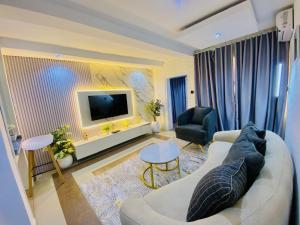 a living room with a couch and a tv at The Royal Enclave in Abuja