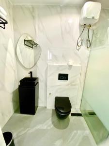 a bathroom with a black toilet and a mirror at The Royal Enclave in Abuja