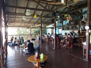 a group of people sitting at tables in a restaurant at OK Bungalow in Ko Tao