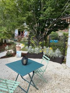 a picnic table and two chairs in a garden at La Félicité in Boissy-le-Sec