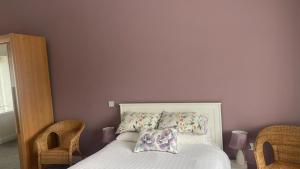 a bedroom with a bed and two wicker chairs at Slievebawn Accommodation in Sligo