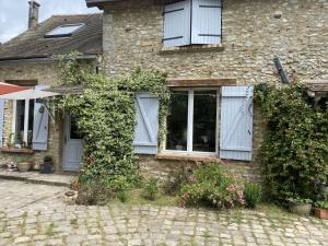 a brick house with white windows and ivy at La Félicité in Boissy-le-Sec +2 photos