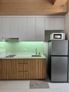a kitchen with a sink and a refrigerator at J-Stays 2BR Beach Condo at Seafront Residences in San Juan