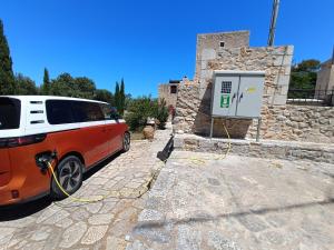 a van parked in front of a stone building with a gas pump at Fameliti Casa Torre - Historic Maniot Tower House in Stavríon
