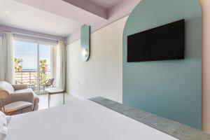 a living room with a bed and a television on a wall at Blue Malva in Valencia