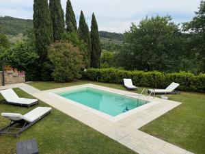 a swimming pool in a yard with two lounge chairs at Casa Alessandra in Arezzo