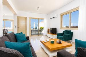a living room with a couch and a table at Villa Diana Seaside in Pomos