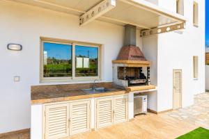 a kitchen with an outdoor kitchen with a brick oven at Villa Diana Seaside in Pomos