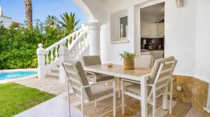 a dining room with a table and chairs next to a pool at Villa Renoir by Goveralia in Oliva
