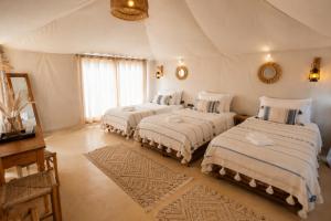 a bedroom with two beds in a room at Aladdin merzouga camp in Merzouga +215 photos