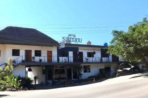 a large white building with a balcony on top of it at Samanu Hotel & Suites in Sayulita