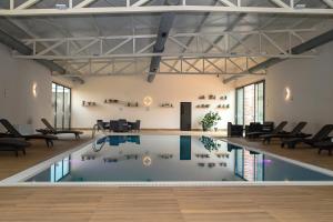 an indoor pool in a room with chairs and tables at Boutique Hotel Ukus in Tešanj