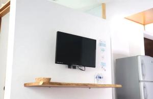 a flat screen tv hanging on a wall next to a refrigerator at Samanu Hotel & Suites in Sayulita