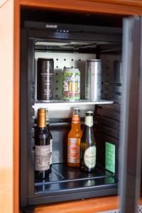 a shelf with bottles of alcohol in a refrigerator at Locanda La Scottiglia in Seggiano
