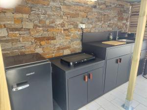 a kitchen with a counter with a grill and a sink at Chalet proche aéroport de Bastia in Lucciana