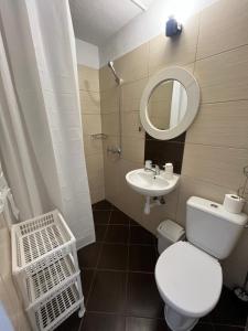 ein Badezimmer mit Toilette, Waschbecken und Spiegel in der Unterkunft Dom Wakacyjny Karol in Łeba