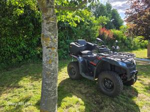 a quad bike parked next to a tree at Le Dômes du Ceyssoux in Le Brignon