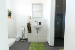 a bathroom with a sink and a mirror at Salz & Seele Das Spa Ferienhaus mit Whirlpool, Sauna & Wallbox in Büsum +9 photos