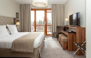 a hotel room with a bed and a television at Hôtel Eden by Odalys in Arc 1800