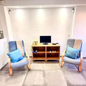 a living room with two chairs and a television at Hercules in Arroyo de la Miel