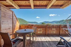 a patio with a table and chairs on a deck at Schwabl Auf Der Ebene in Meltina