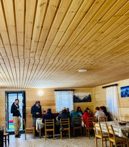 a group of people sitting at tables in a restaurant at Bata GuesThouse in Adishi