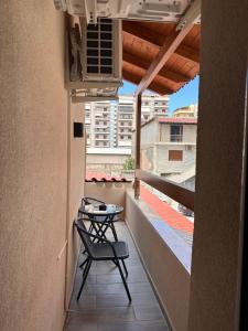 a balcony with a table and a chair on a building at Kanaj Rooms and Apartments in Vlorë