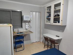 a small kitchen with two stools and a counter top at kitnet individual Campinas in Campinas