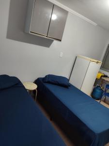 a bedroom with a blue bed and a table at kitnet individual Campinas in Campinas