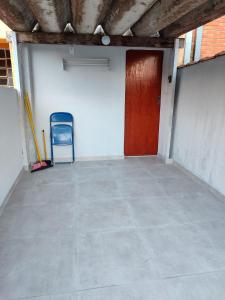 an empty garage with a door and a chair at kitnet individual Campinas in Campinas