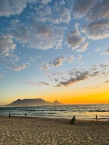 a group of people on the beach at sunset at Blouberg Beach Gem 5 Min Walk in Cape Town