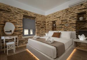 a bedroom with a bed and a table and a mirror at Lithoskino Suites in Batsi