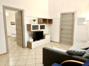 a living room with a couch and a television at Il Posto Giusto tra cielo e mare in Pantelleria