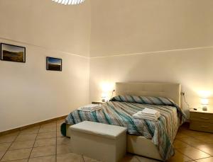 a bedroom with a bed and a stool and two lamps at Il Posto Giusto tra cielo e mare in Pantelleria