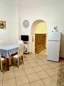 a kitchen and dining room with a table and a refrigerator at Il Posto Giusto tra cielo e mare in Pantelleria