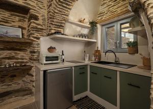 a small kitchen with a sink and a microwave at Lithoskino Suites in Batsi +26 photos
