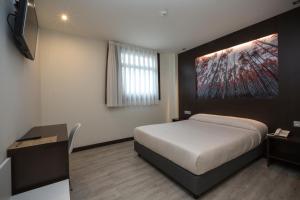 A bed or beds in a room at Hotel la Posada de Roces