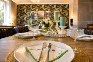 a table with plates and silverware on top of it at Traumhaus Thale mit Sauna und Kamin in Thale