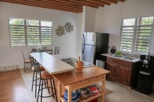 a kitchen with a wooden table and a refrigerator at New Mountain Escape Panoramic San Juan Views in Aguas Buenas