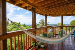 a hammock on the deck of a cabin at New Mountain Escape Panoramic San Juan Views in Aguas Buenas
