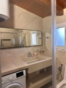 a bathroom with a sink and a mirror at Kanaj Rooms and Apartments in Vlorë